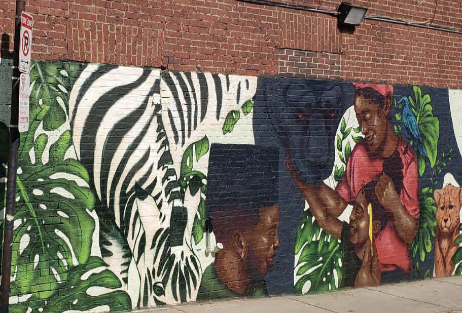 Mural of a zebra and figures among monstera leaves on the Fox Hall building